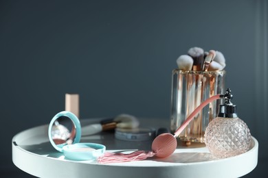 Photo of Different makeup products on white table against grey background, closeup