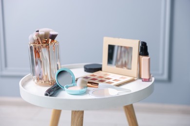Photo of Different makeup products on white table indoors, closeup