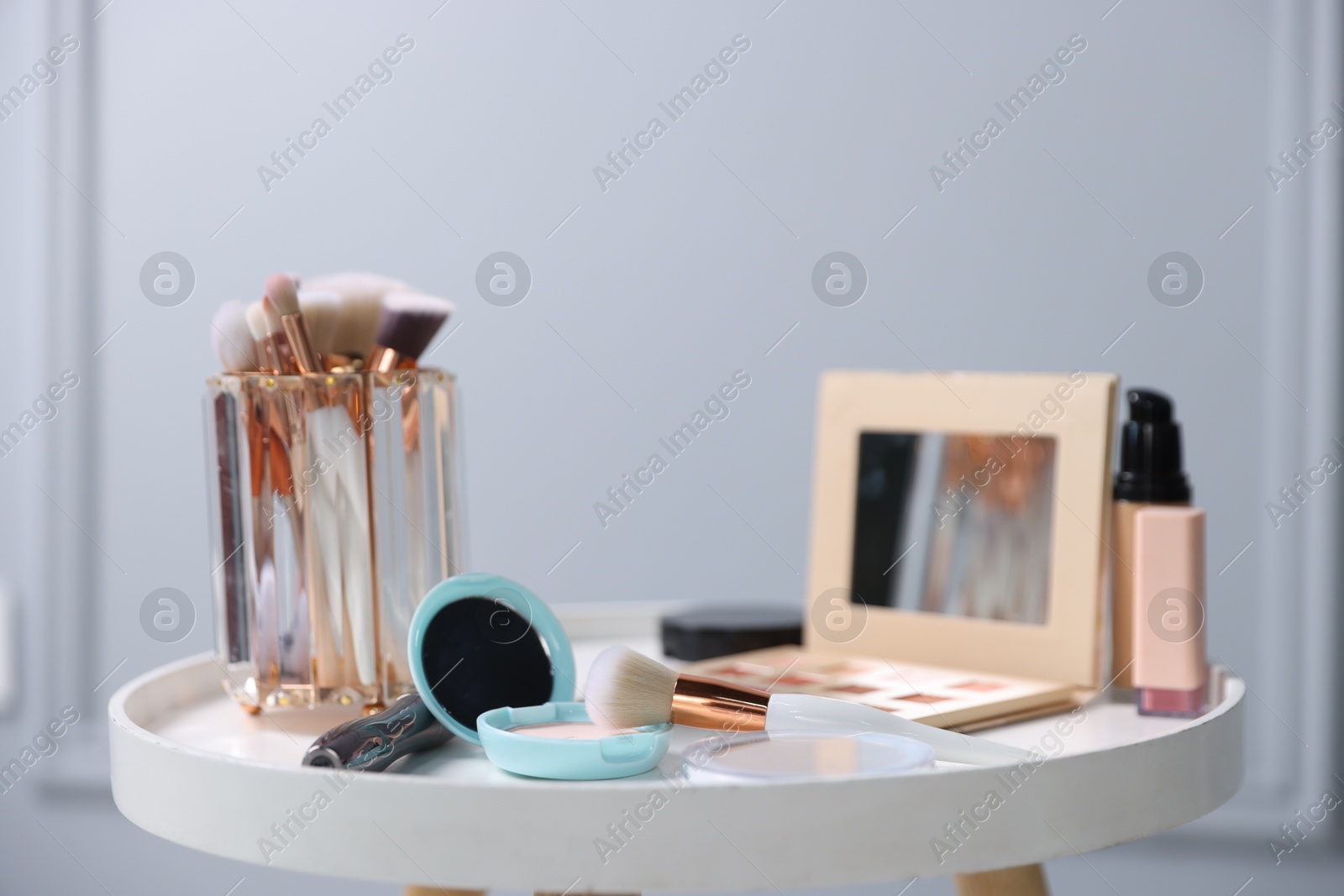Different makeup products on white table indoors, closeup Photo of Different makeup products on white table indoors, closeup