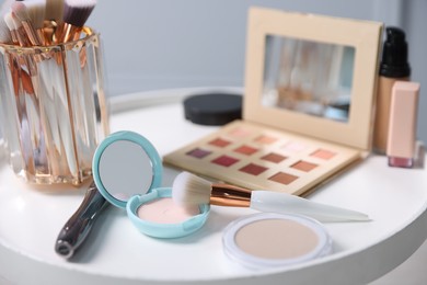 Photo of Different makeup products on white table indoors, closeup