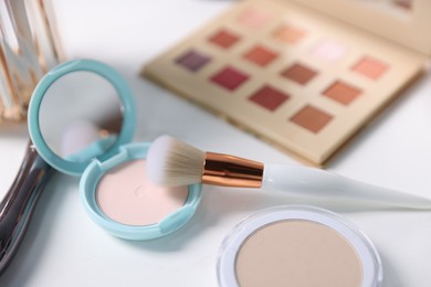 Photo of Different makeup products on white table, closeup
