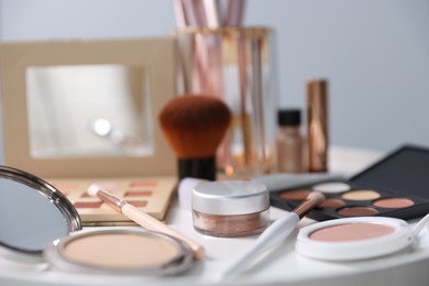 Photo of Different makeup products on white table indoors, closeup