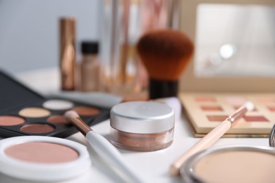 Photo of Different makeup products on white table indoors, closeup