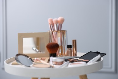 Photo of Different makeup products on white table indoors, closeup
