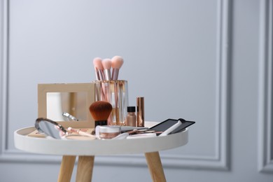 Photo of Different makeup products on white table indoors, space for text