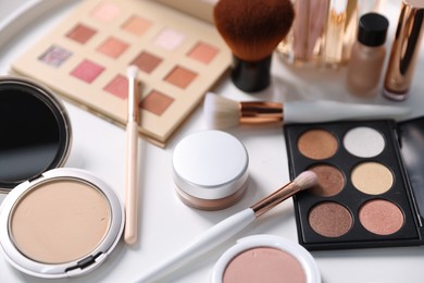 Photo of Different makeup products on white table, closeup