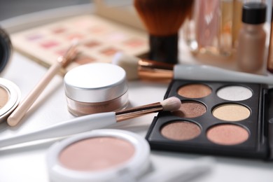 Photo of Different makeup products on white table, closeup