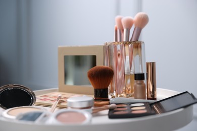 Photo of Different makeup products on white table indoors, closeup