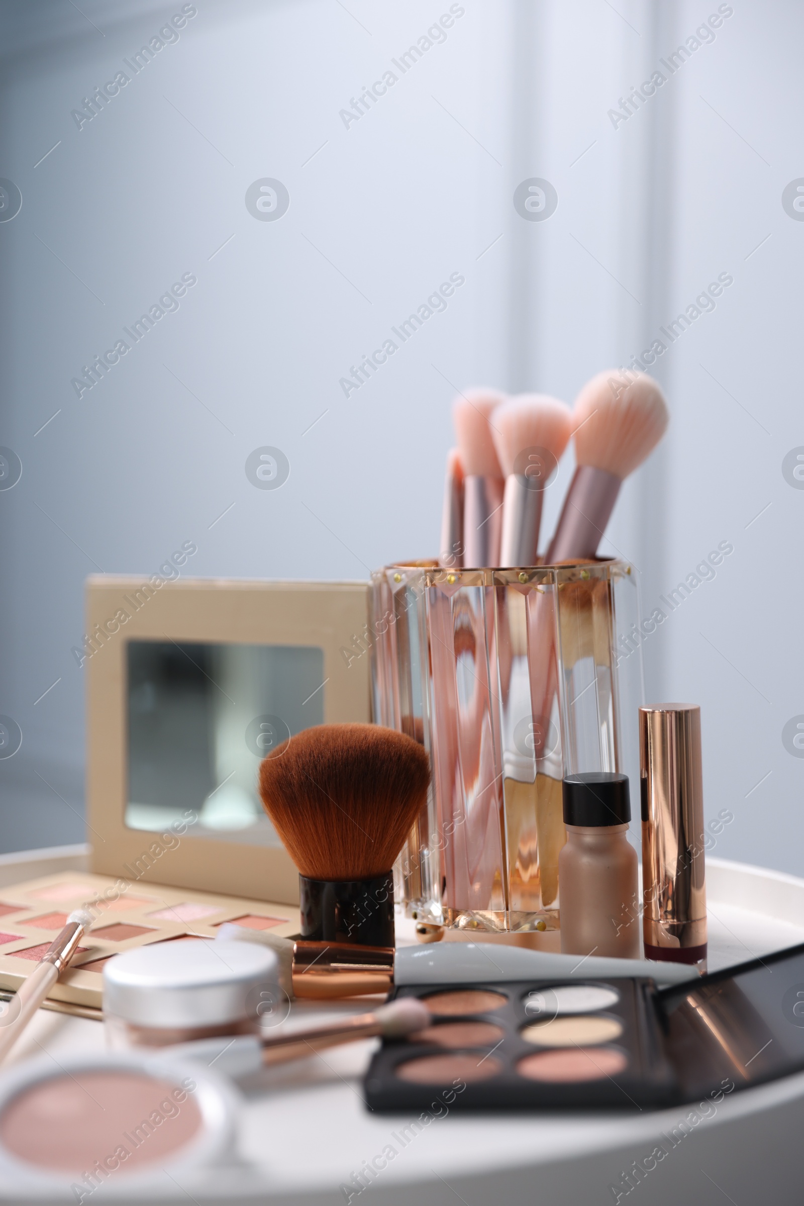 Different makeup products on white table indoors, closeup Photo of Different makeup products on white table indoors, closeup