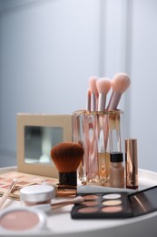 Photo of Different makeup products on white table indoors, closeup