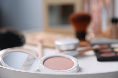 Photo of Different makeup products on white table indoors, closeup