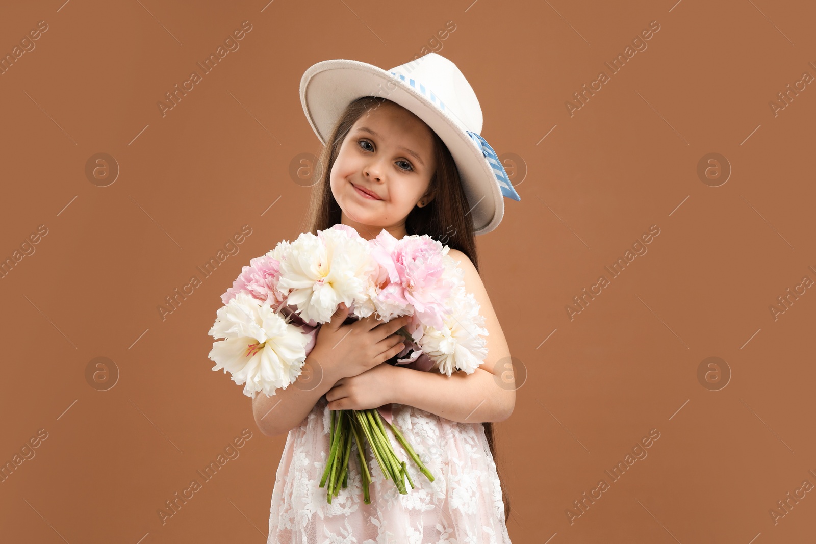 Cute little girl with bouquet of beautiful peonies on brown background Photo of Cute little girl with bouquet of beautiful peonies on brown background