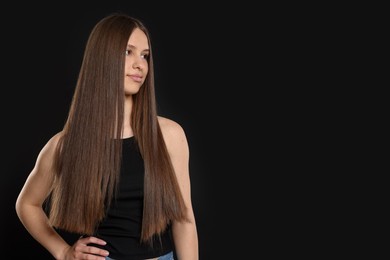 Photo of Beautiful teenage girl with healthy long hair on black background. Space for text