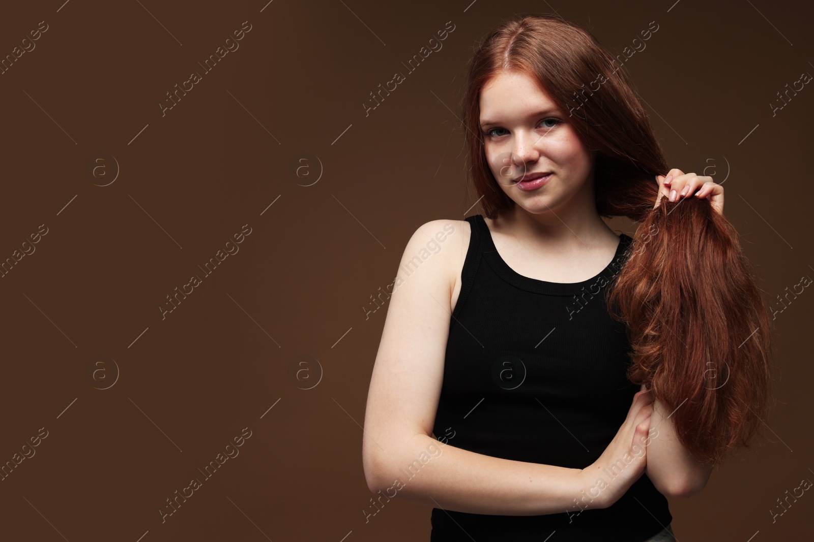 Portrait of beautiful teenage girl with healthy wavy hair on brown background. Space for text Photo of Portrait of beautiful teenage girl with healthy wavy hair on brown background. Space for text