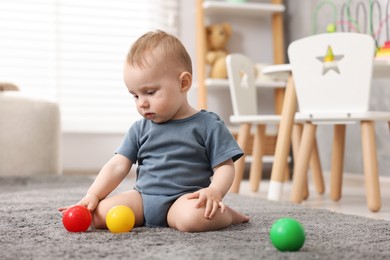 Photo of Cute little baby playing with toys in room