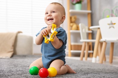 Photo of Cute little baby playing with toys in room
