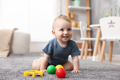 Photo of Cute little baby playing with toys in room