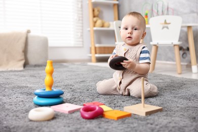 Photo of Cute little baby playing with toys in room