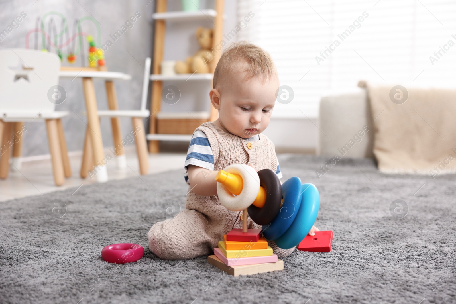 Cute little baby playing with toys in room Photo of Cute little baby playing with toys in room