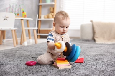 Photo of Cute little baby playing with toys in room