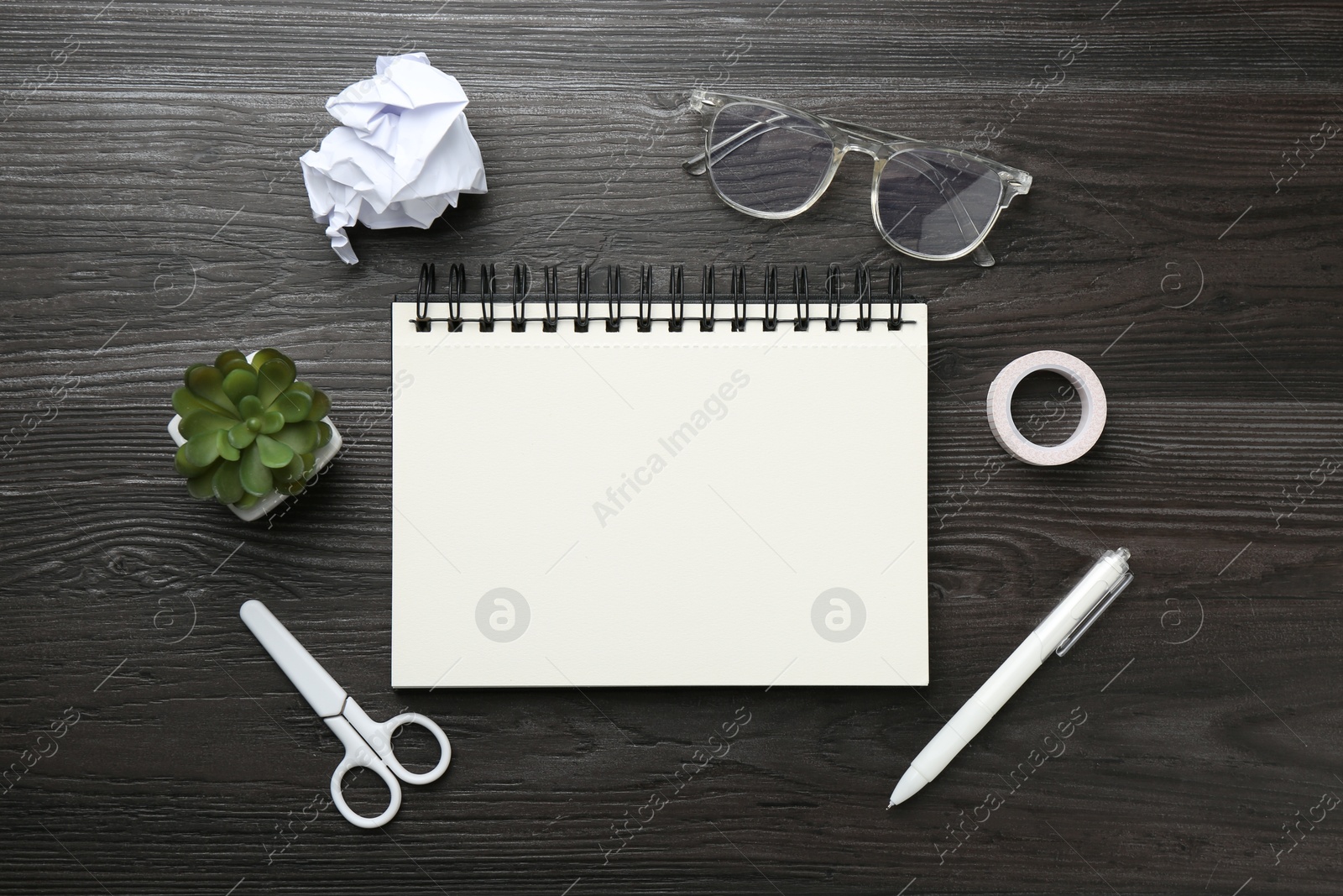 Photo of Flat lay composition with open blank notebook on black wooden table