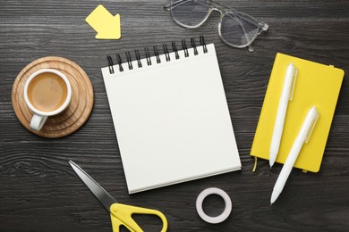 Photo of Flat lay composition with open blank notebook on black wooden table