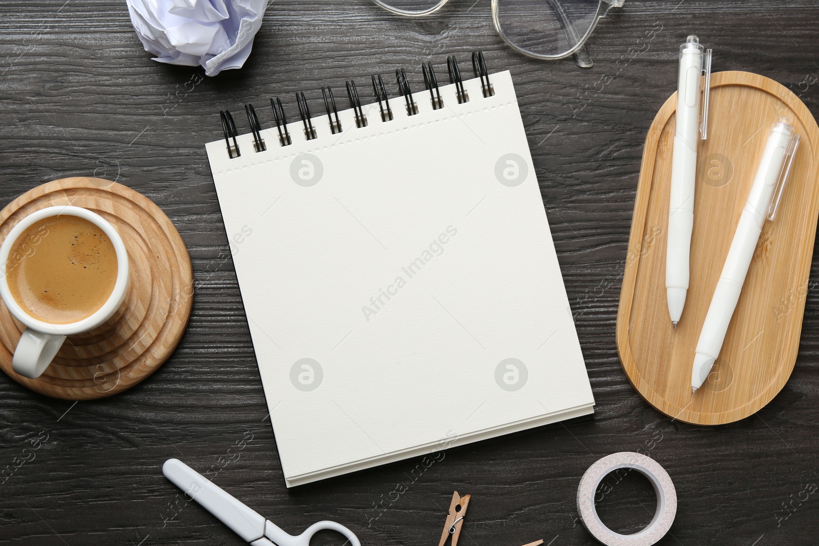Photo of Flat lay composition with open blank notebook on black wooden table