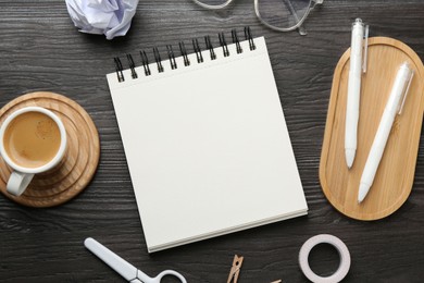 Photo of Flat lay composition with open blank notebook on black wooden table