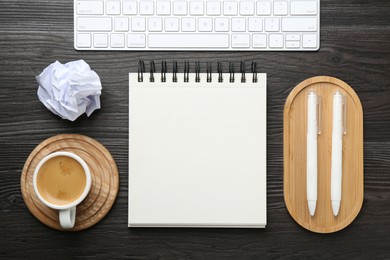Photo of Flat lay composition with open blank notebook on black wooden table