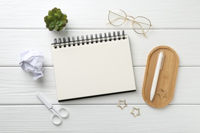 Photo of Flat lay composition with open blank notebook on white wooden table