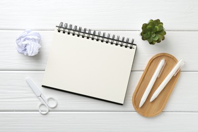 Photo of Flat lay composition with open blank notebook on white wooden table