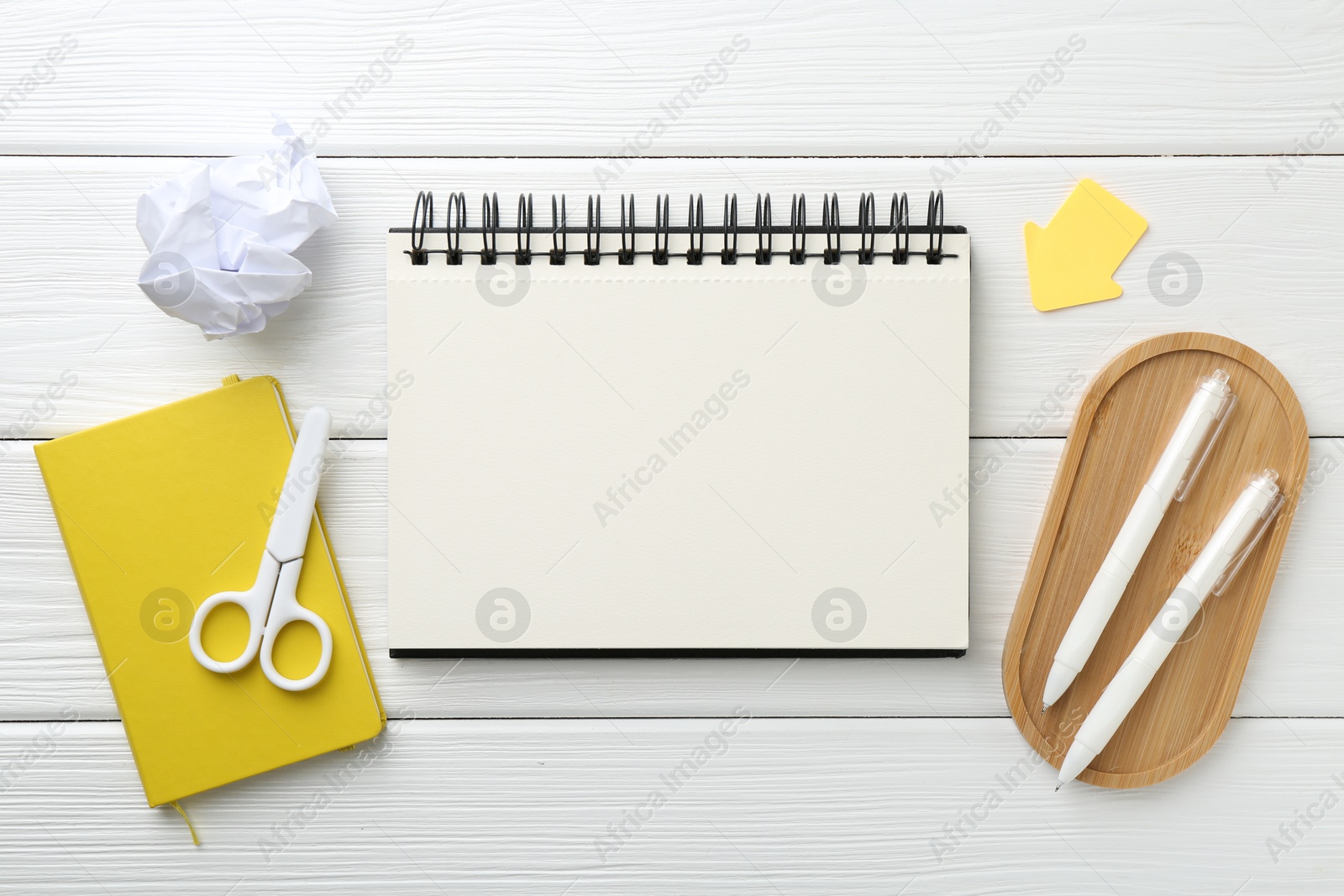 Photo of Flat lay composition with open blank notebook on white wooden table