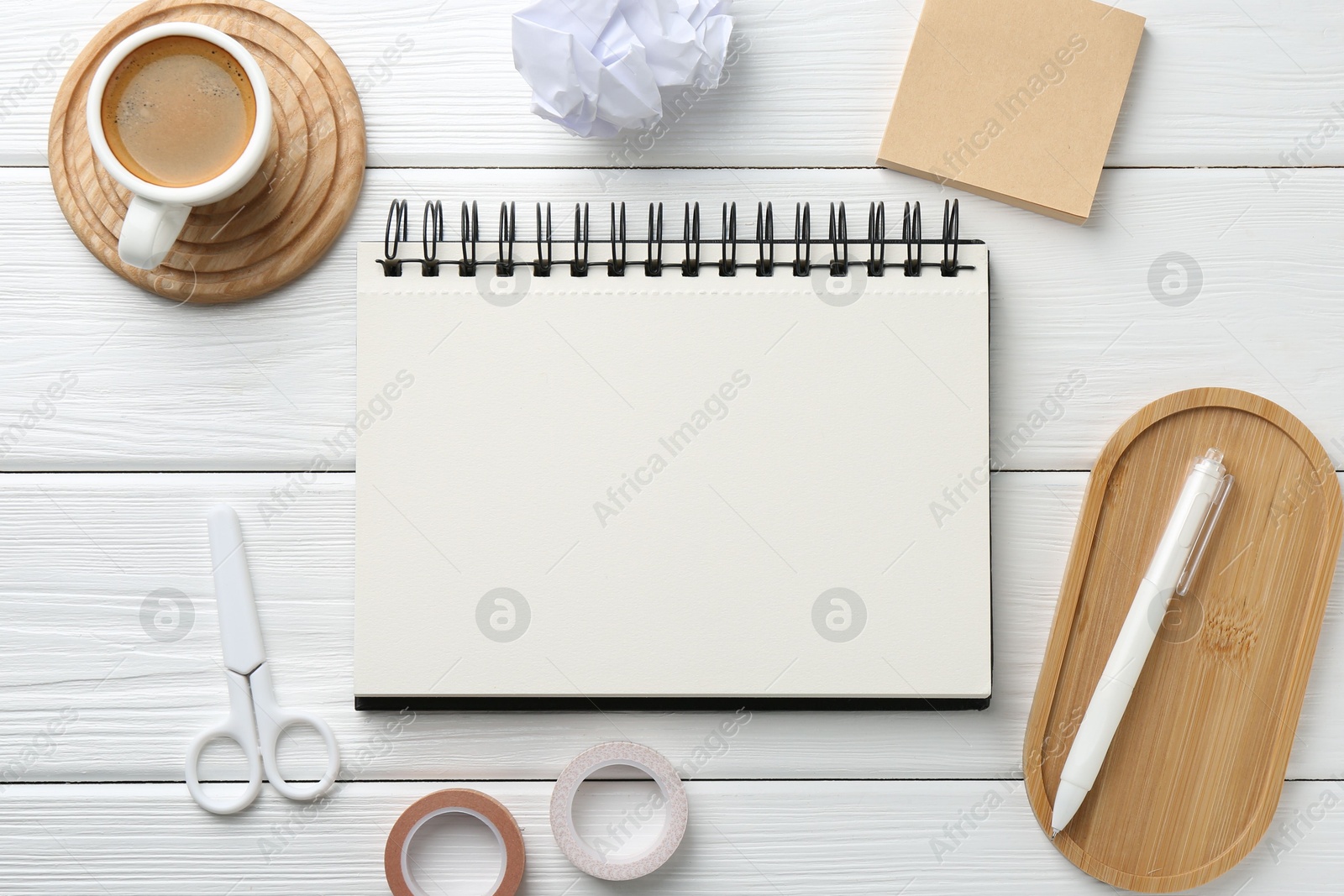 Photo of Flat lay composition with open blank notebook on white wooden table