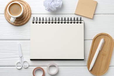 Photo of Flat lay composition with open blank notebook on white wooden table