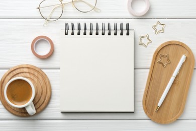 Photo of Flat lay composition with open blank notebook on white wooden table