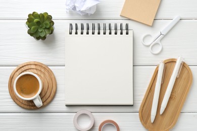 Photo of Flat lay composition with open blank notebook on white wooden table