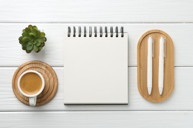 Photo of Flat lay composition with open blank notebook on white wooden table