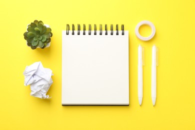 Photo of Flat lay composition with open blank notebook on yellow background