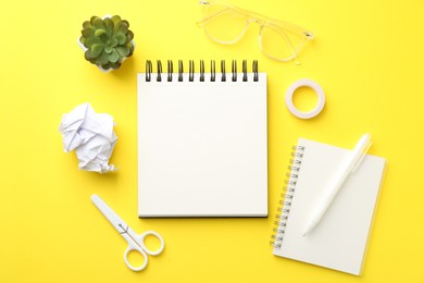 Photo of Flat lay composition with open blank notebook on yellow background