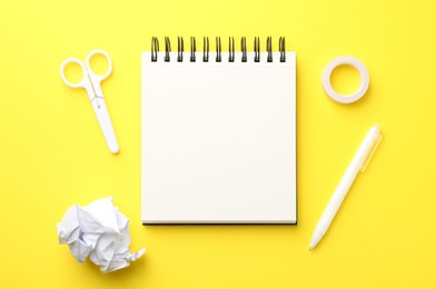 Photo of Flat lay composition with open blank notebook on yellow background