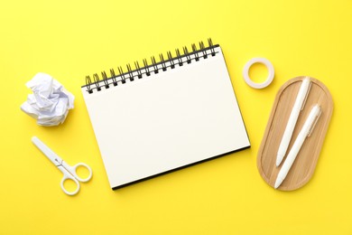 Photo of Flat lay composition with open blank notebook on yellow background