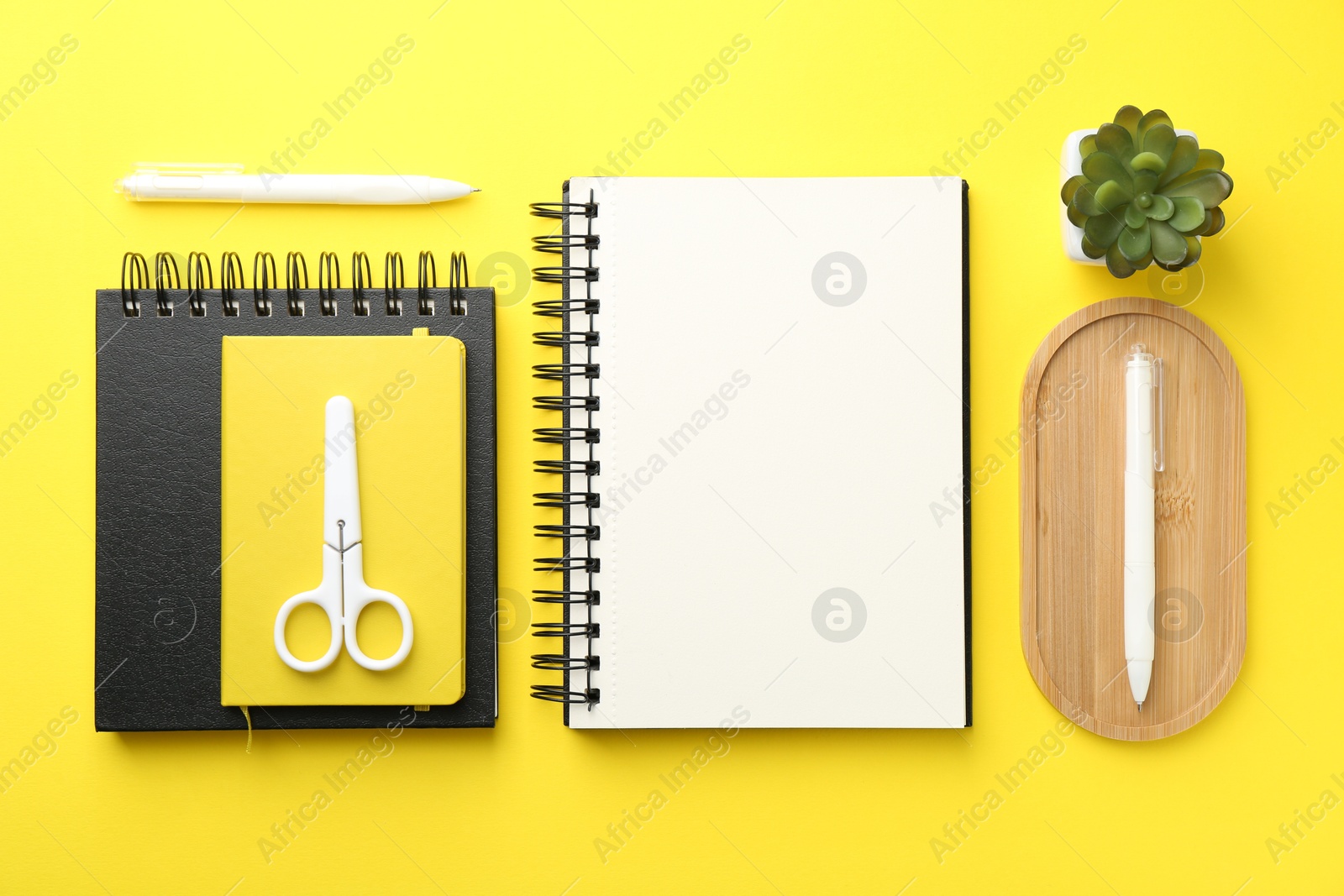 Photo of Flat lay composition with open blank notebook on yellow background