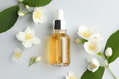 Photo of Cosmetic product and jasmine flowers on light background, flat lay