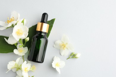Photo of Cosmetic product and jasmine flowers on light background, flat lay. Space for text