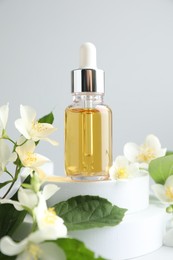 Photo of Cosmetic product and jasmine flowers on light background, closeup