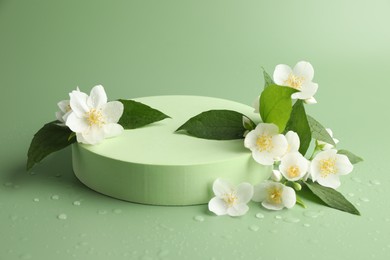 Photo of Beautiful jasmine flowers with leaves on green background
