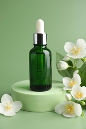 Photo of Cosmetic product and jasmine flowers on green background
