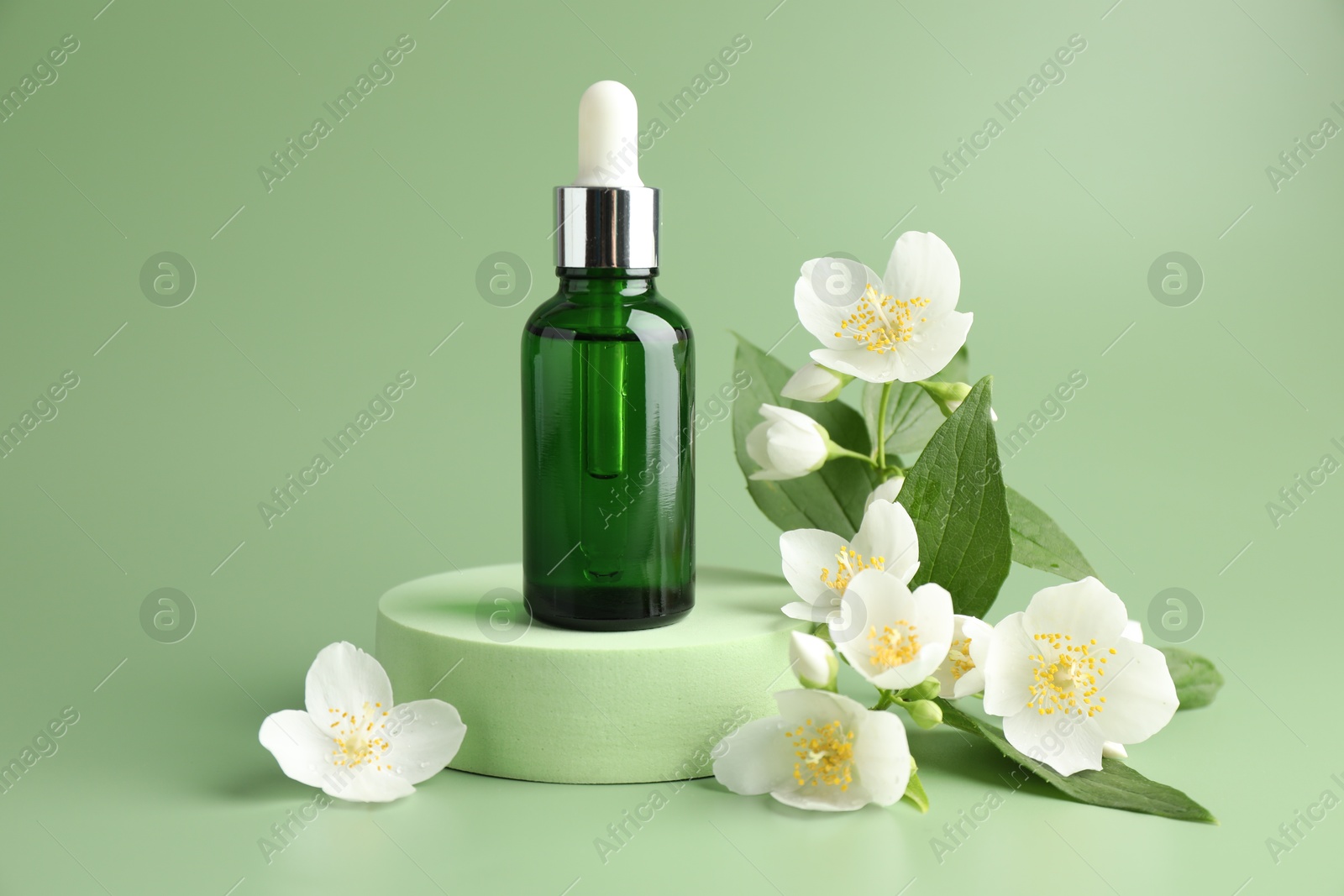 Cosmetic product and jasmine flowers on green background Photo of Cosmetic product and jasmine flowers on green background