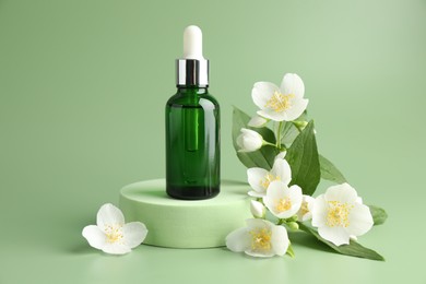 Photo of Cosmetic product and jasmine flowers on green background