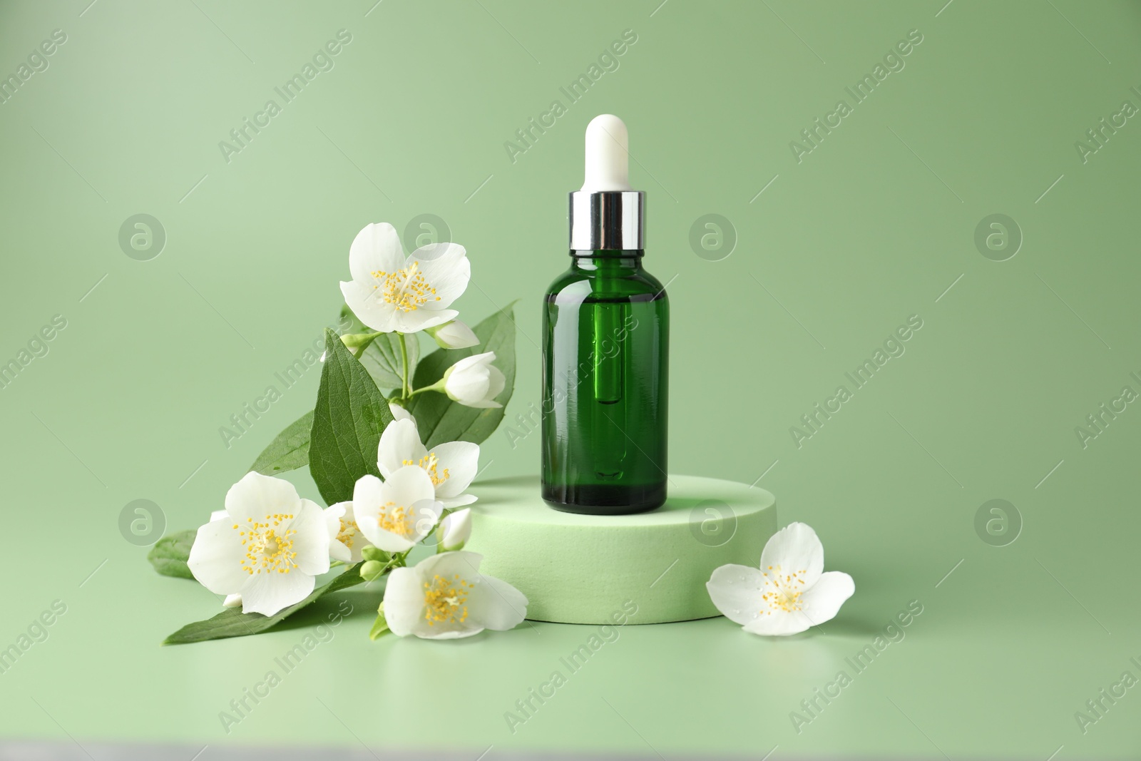 Cosmetic product and jasmine flowers on green background Photo of Cosmetic product and jasmine flowers on green background